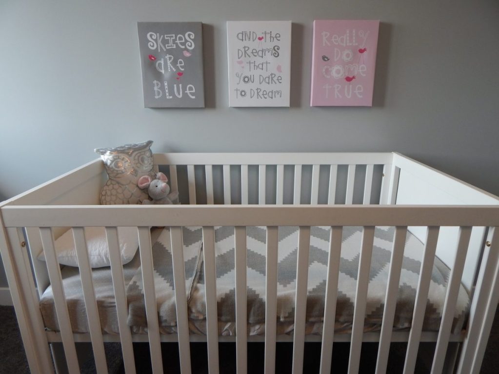 A crib with nursery decor hanging above it
