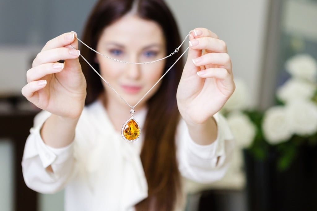 woman holding birthstone necklace