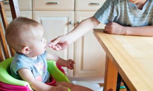 Toddler being spoon-fed breakfast