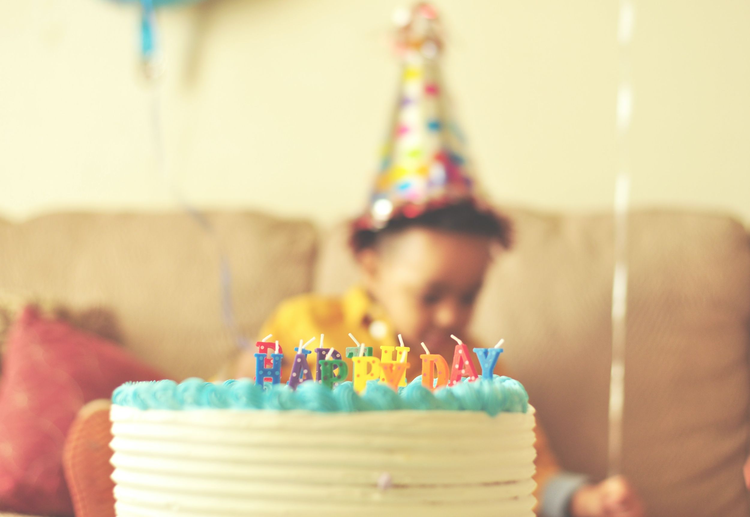 A child celebrating a birthday party with cake in the forefront