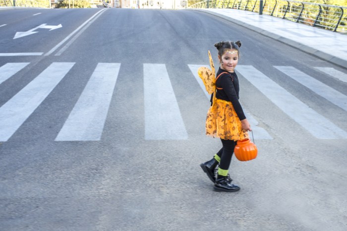 Girl trick or treating in Halloween street
