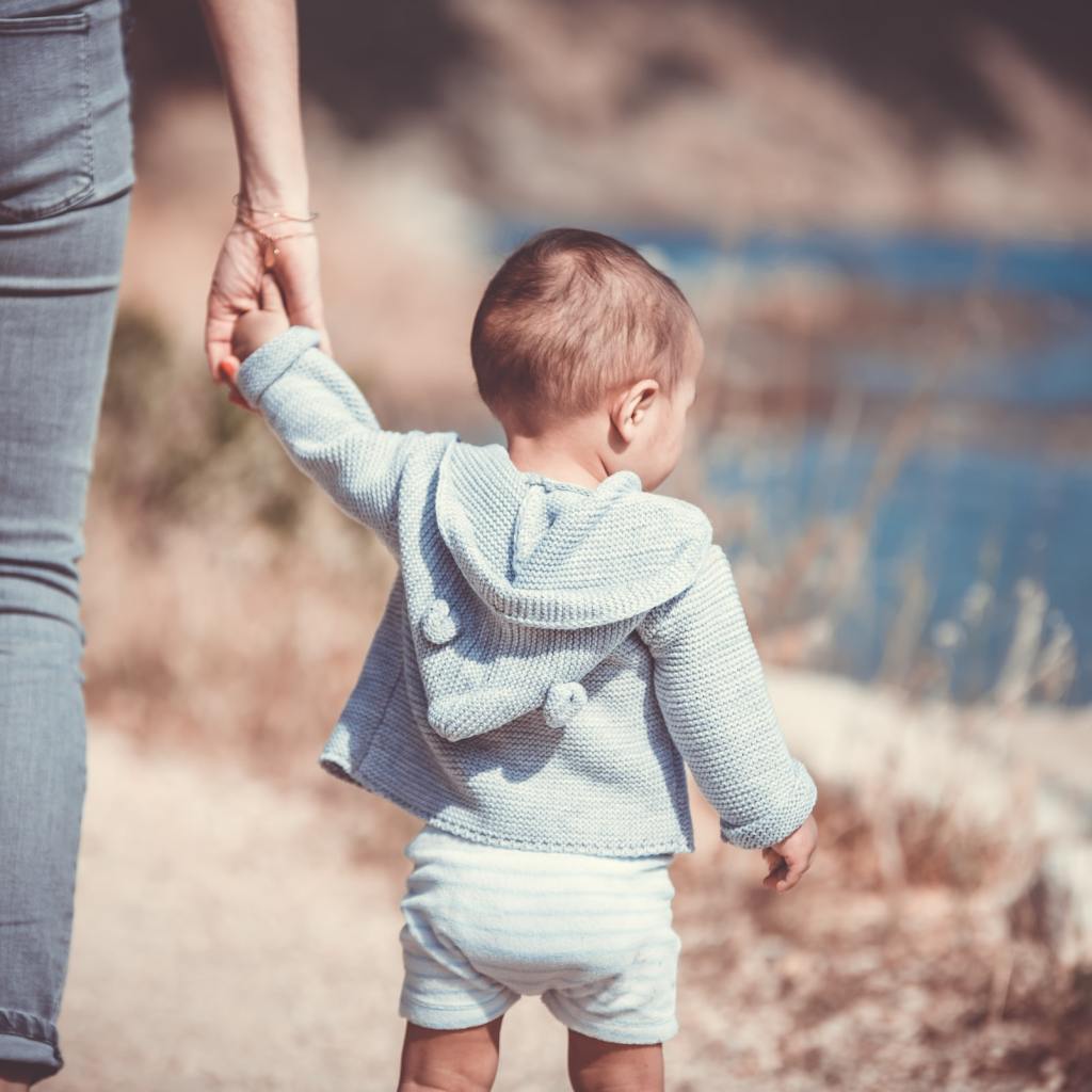 Toddler walking with parent