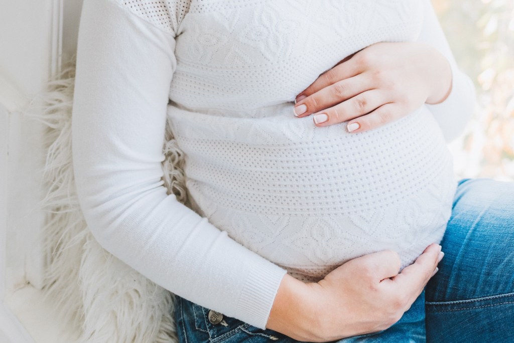 Pregnant woman feeling her baby kick