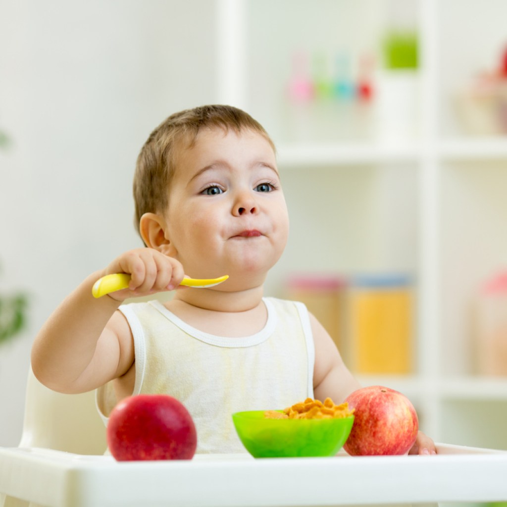 A baby eating baby food.