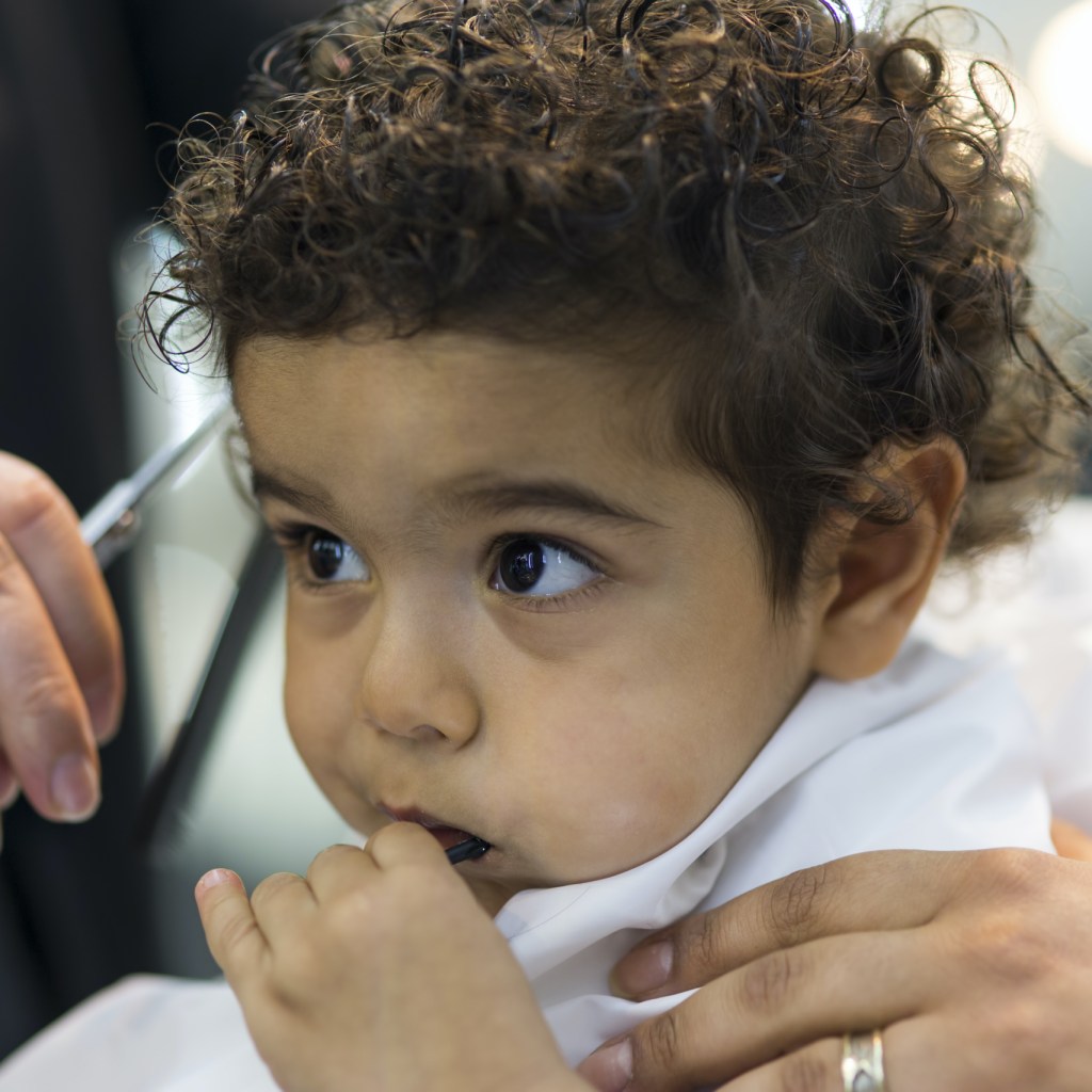 A baby getting their hair cut.