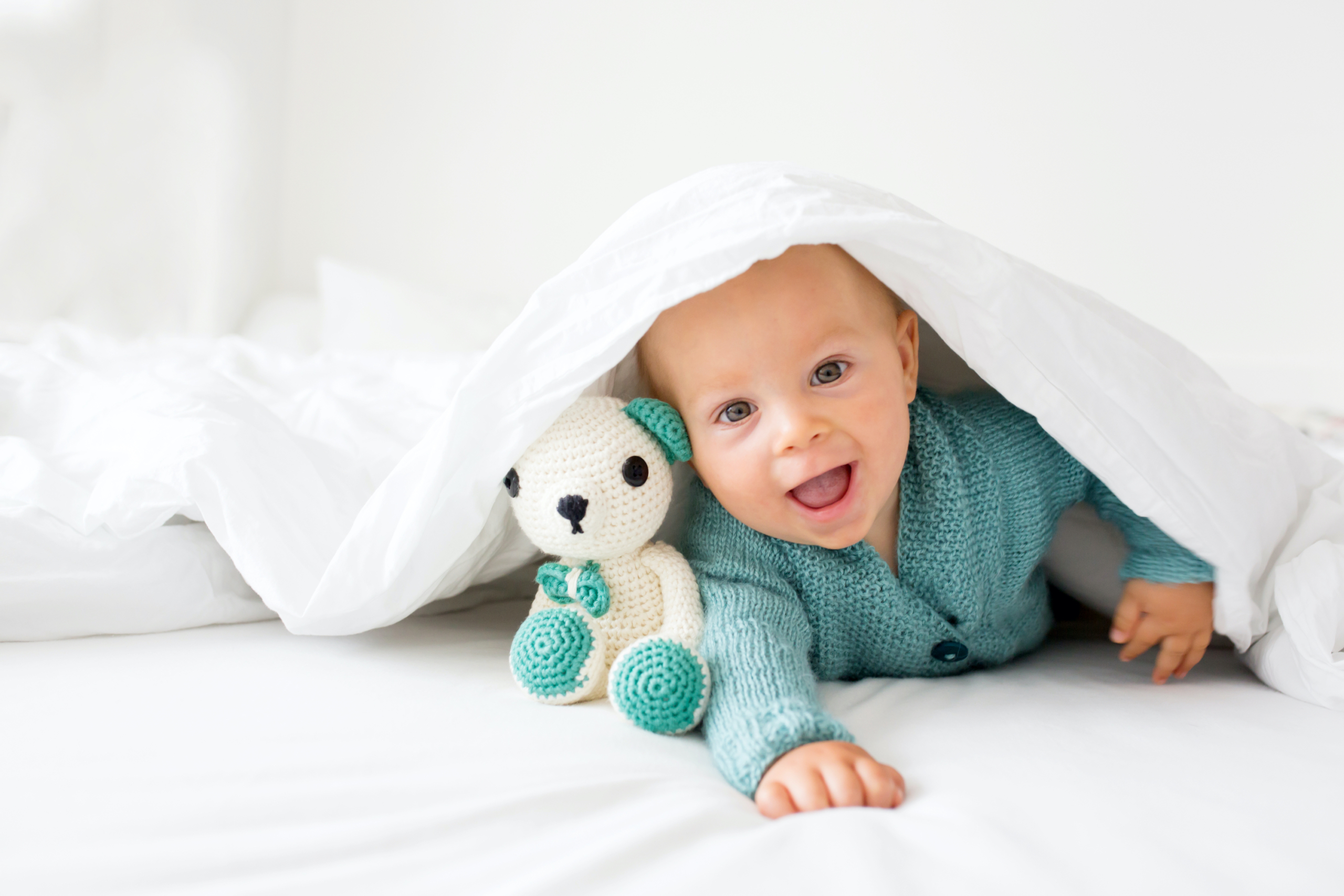 Baby smiling under a blanket