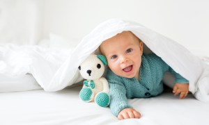 Baby smiling under a blanket