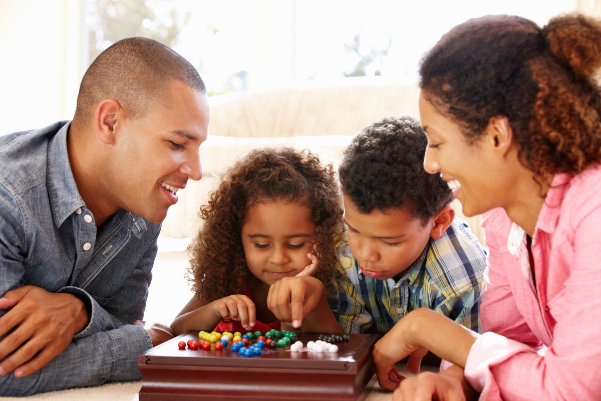 Family at a table playing a board game.