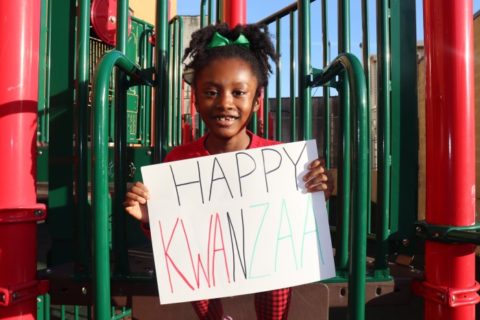 Young girl with Kwanzaa sign on a playground