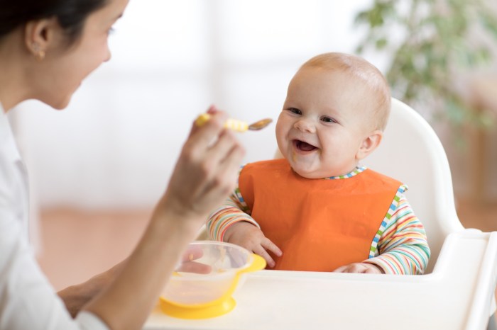 mom spoon-feeding baby food