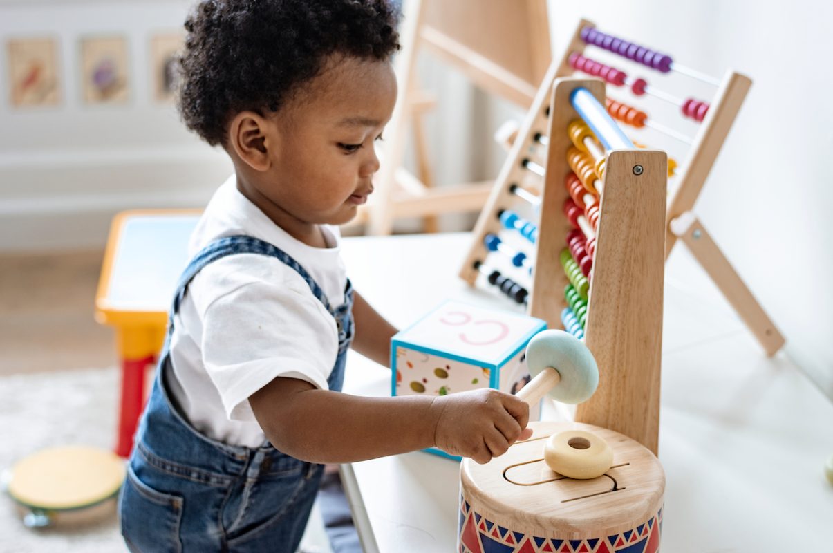 A little boy playing with table toys