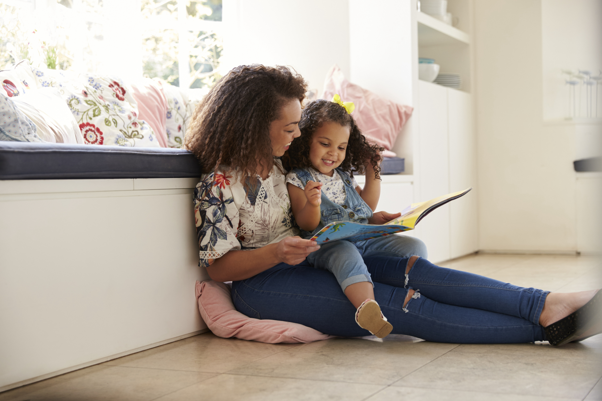 Mother reading a book to her daughter.
