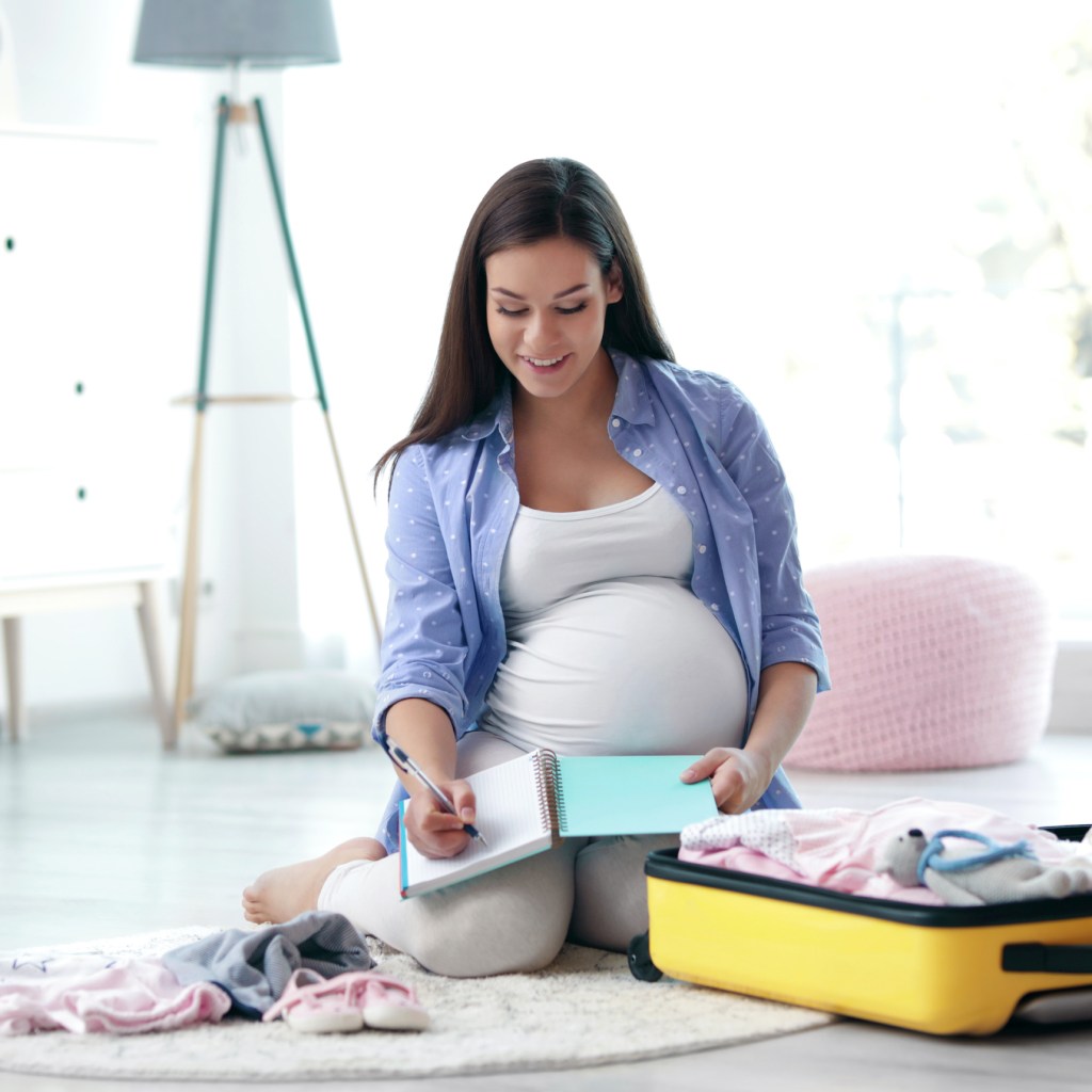 Pregnant woman packing a hospital bag.