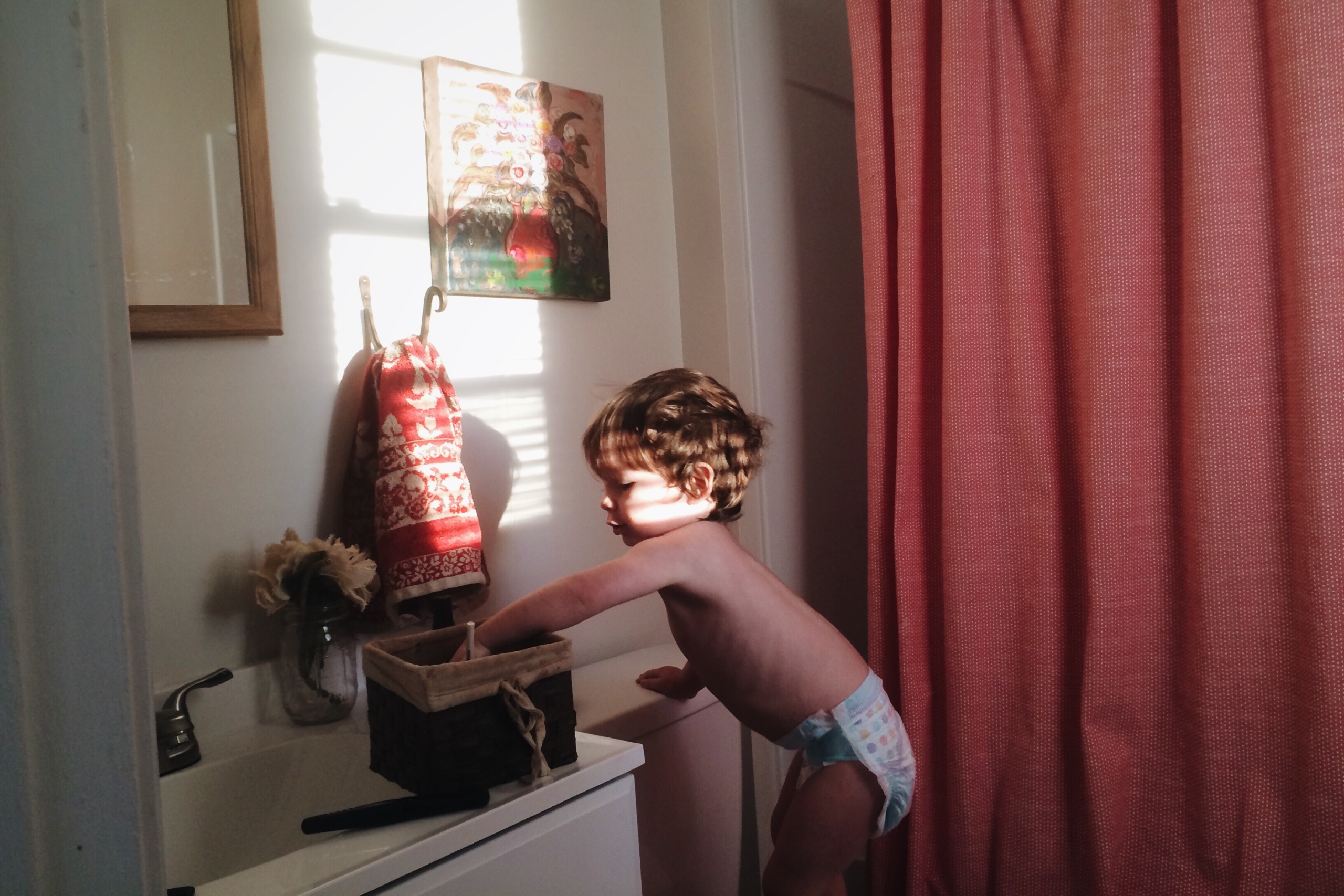 Toddler reaches into a box on a desk