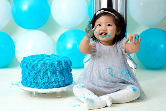 Baby girl is all smiles with her blue first birthday cake
