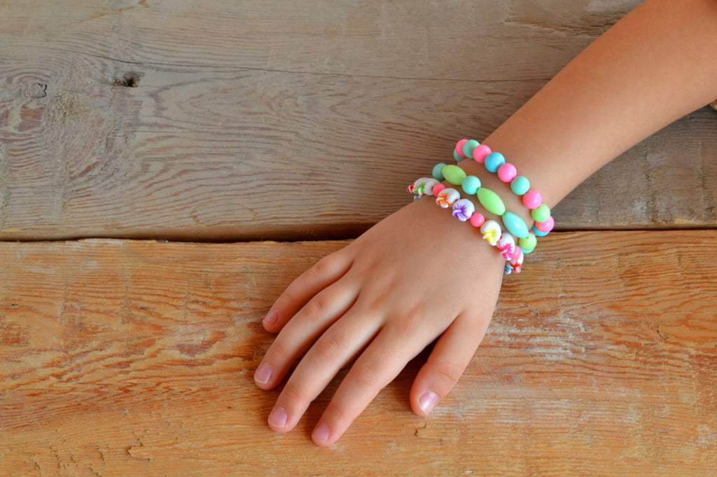young girls hand showing off beaded bracelets
