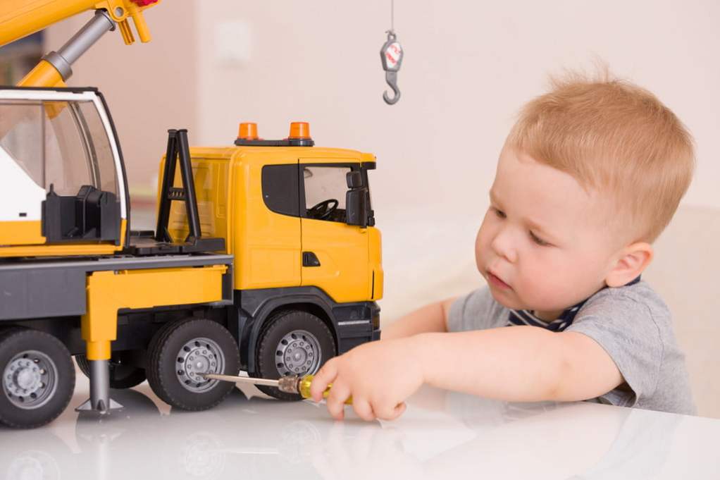 toddler boy playing with a toy truck