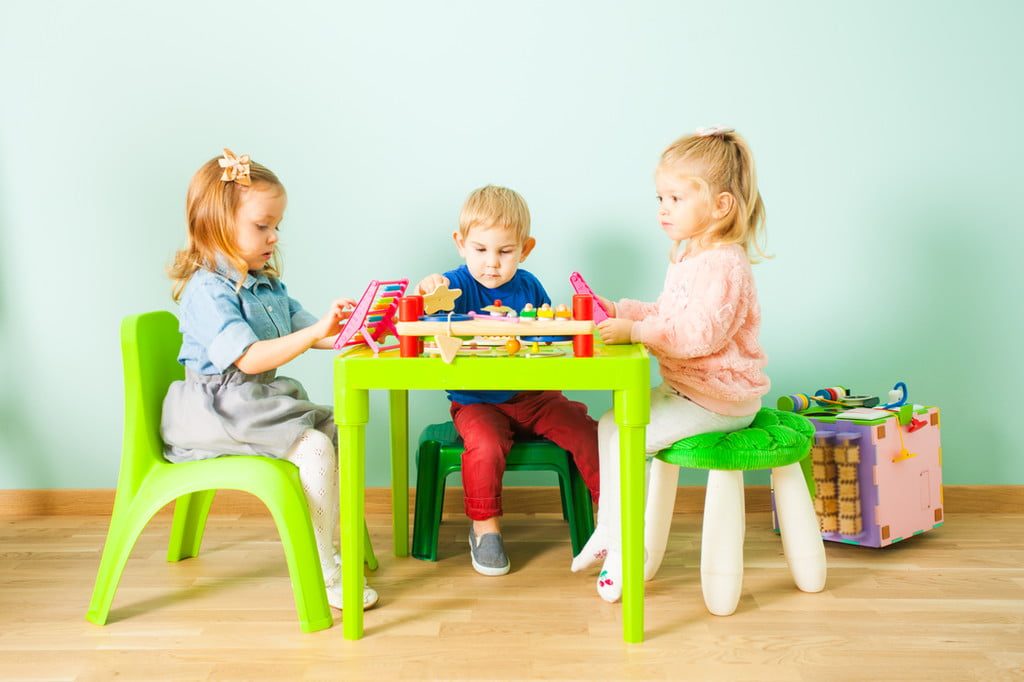 A group of young children at an activity table.