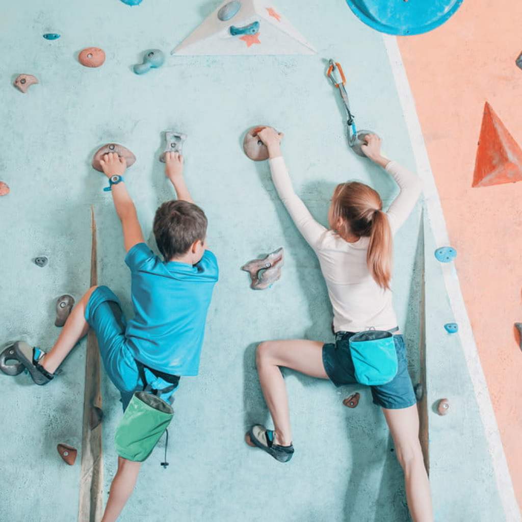 Kids scaling a rock wall