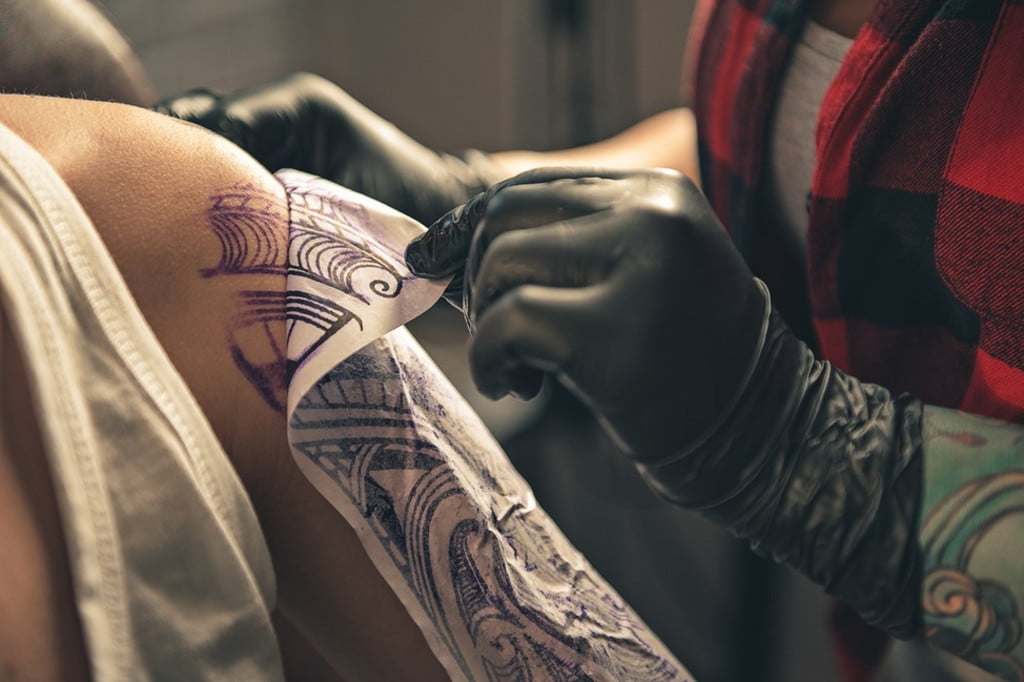 woman getting a tattoo on her arm