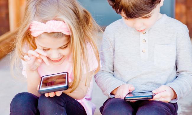 two kids playing on phones
