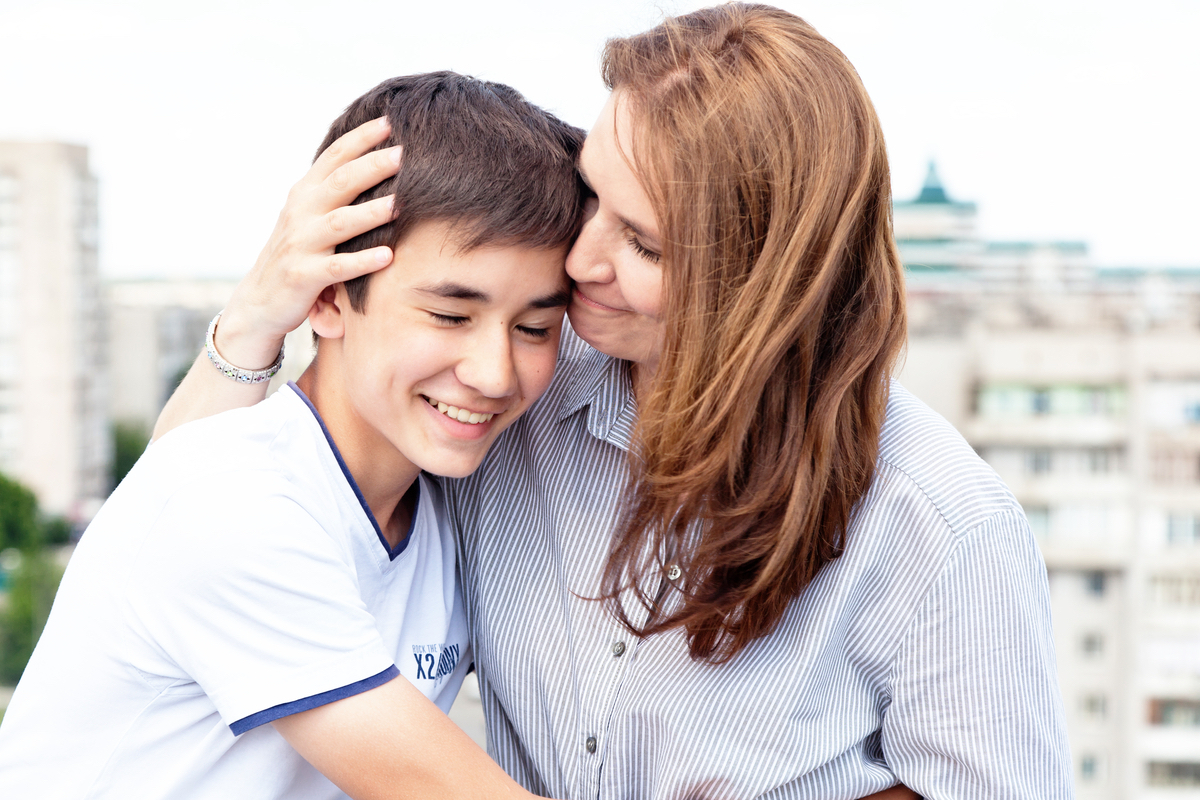 A mom embraces her teenaged son