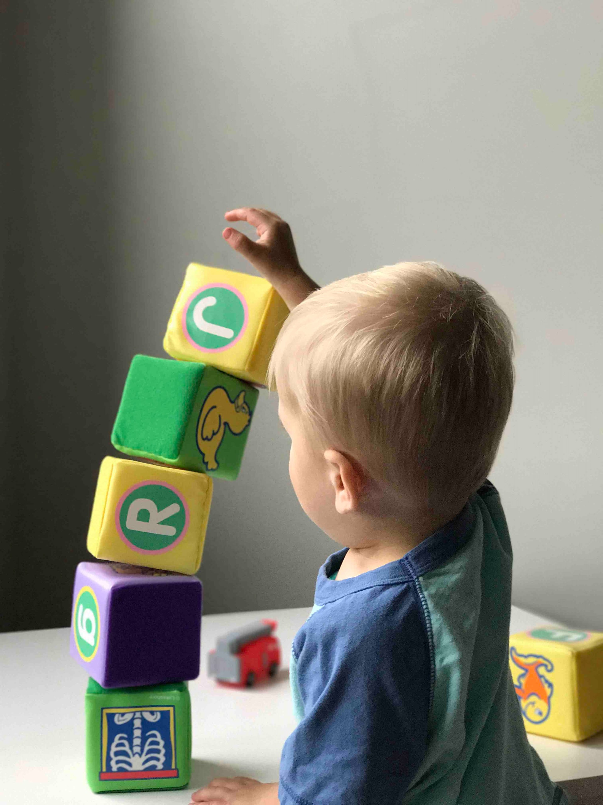 A toddler boy playing with some blocks