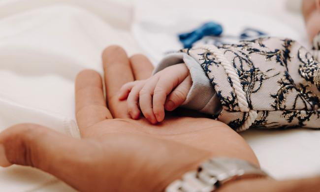 Baby's hand holding parent's hand