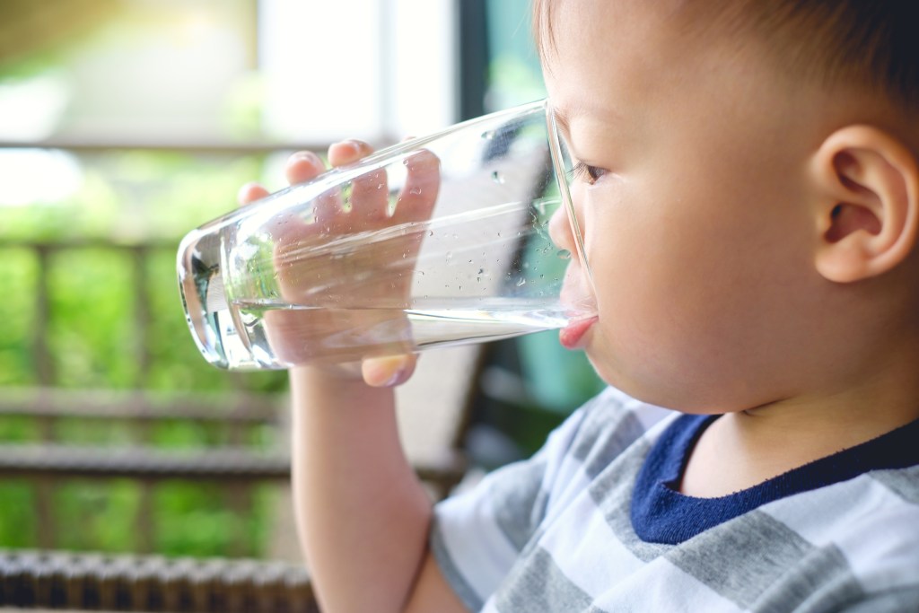 Toddler drinking glass of water.