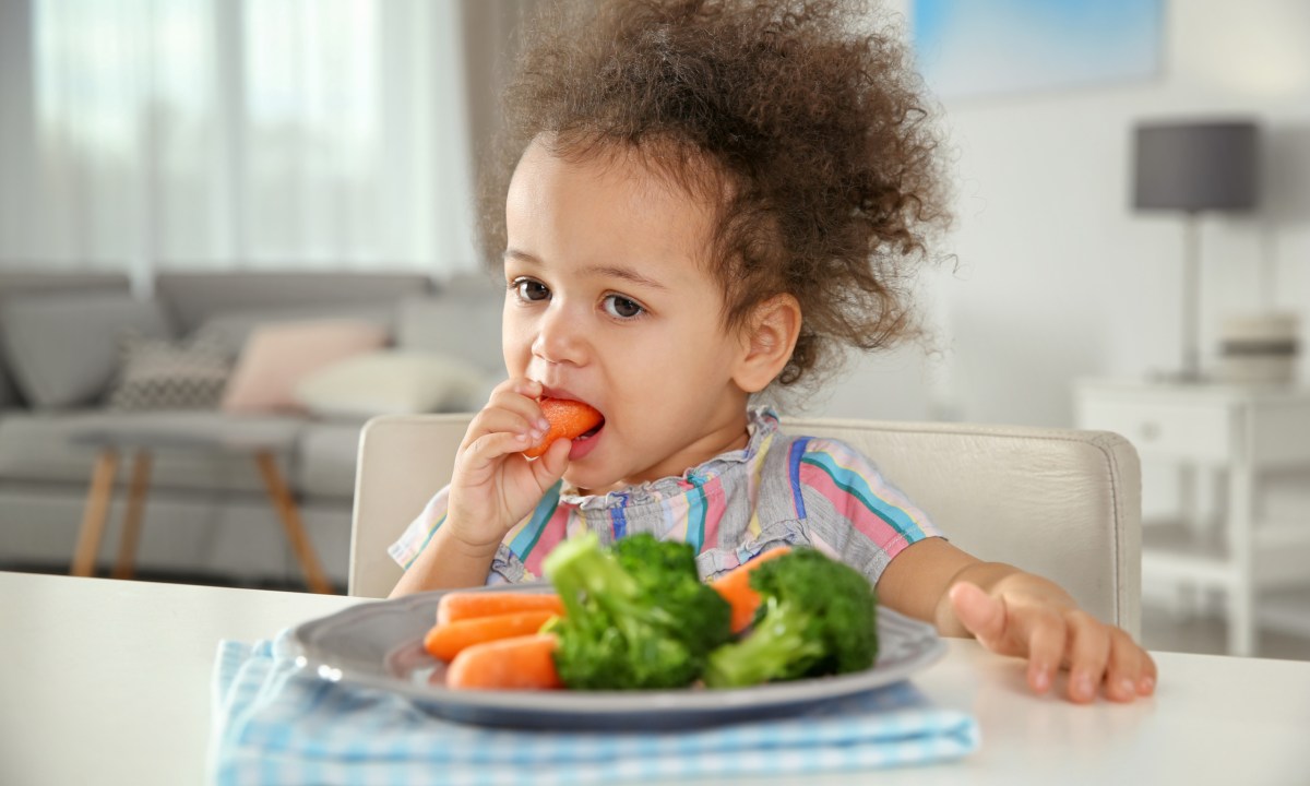 Toddler eating vegetables