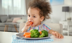 Toddler eating vegetables.