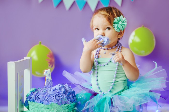 Baby girl enjoying her smash cake on her first birthday