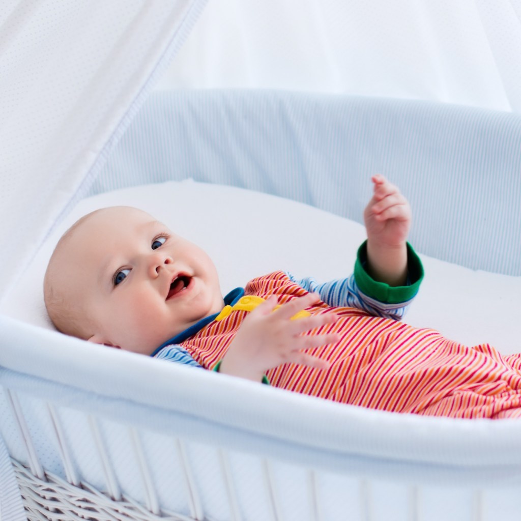Baby smiling in a bassinet