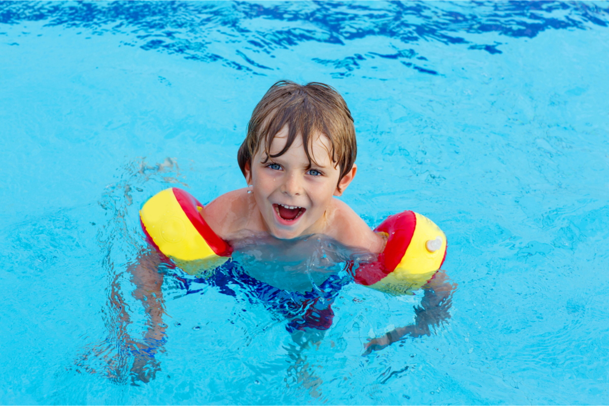 Child in a pool with arm floaties