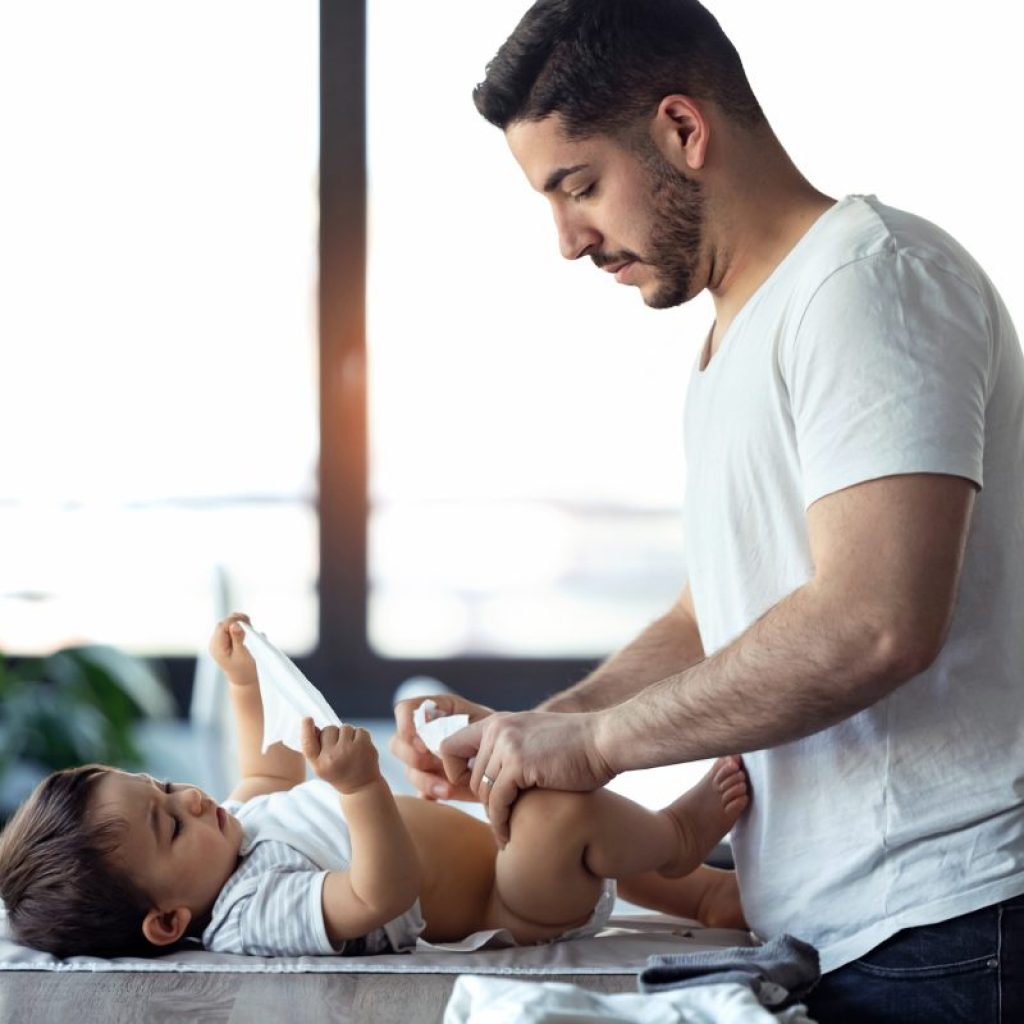Dad changing son's diaper