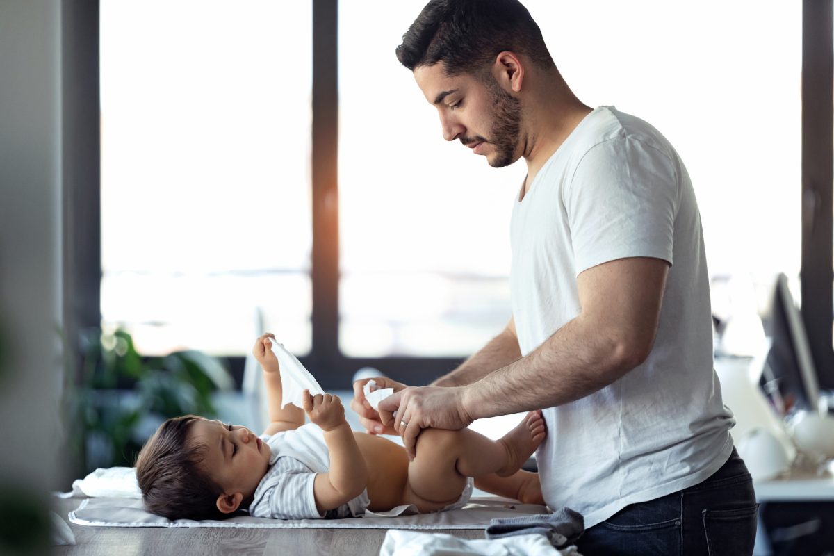 Dad changing son's diaper