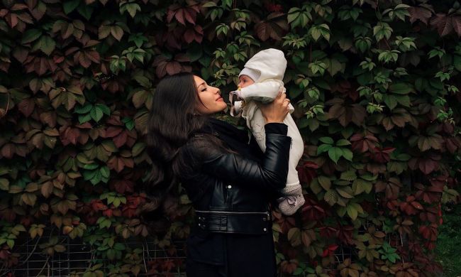 Mom holding baby outside in the winter.