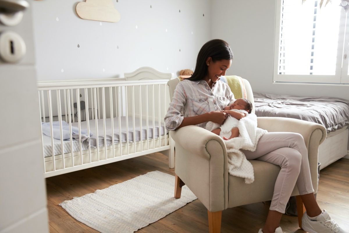 Mother holding a baby in a nursery.