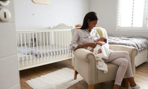 Mother holding a baby in a nursery.