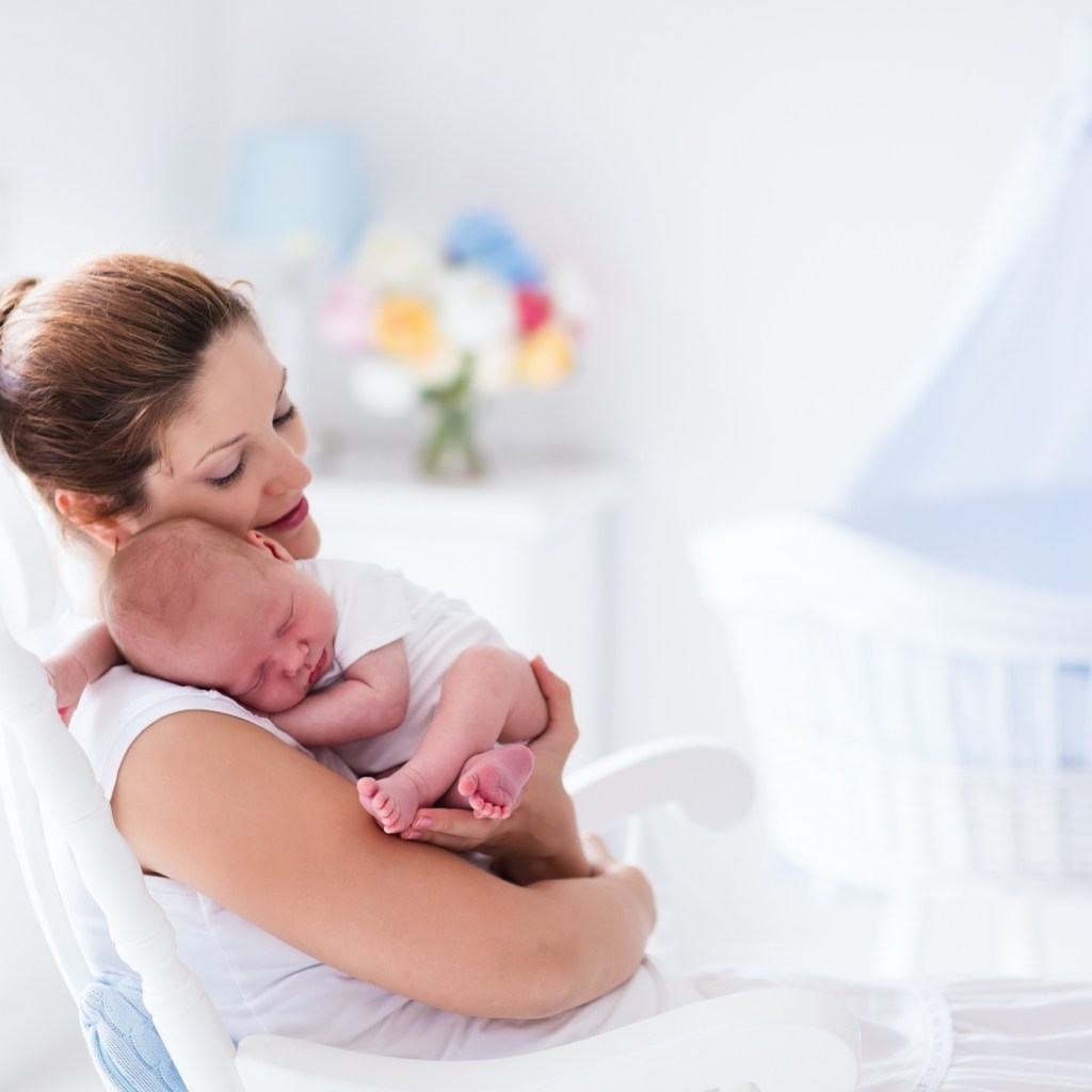 Mother holding a baby in a nursery