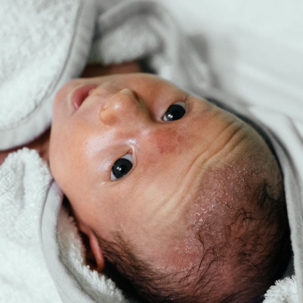 A newborn is swaddled in a towel
