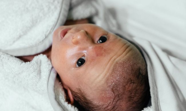 A newborn is swaddled in a towel