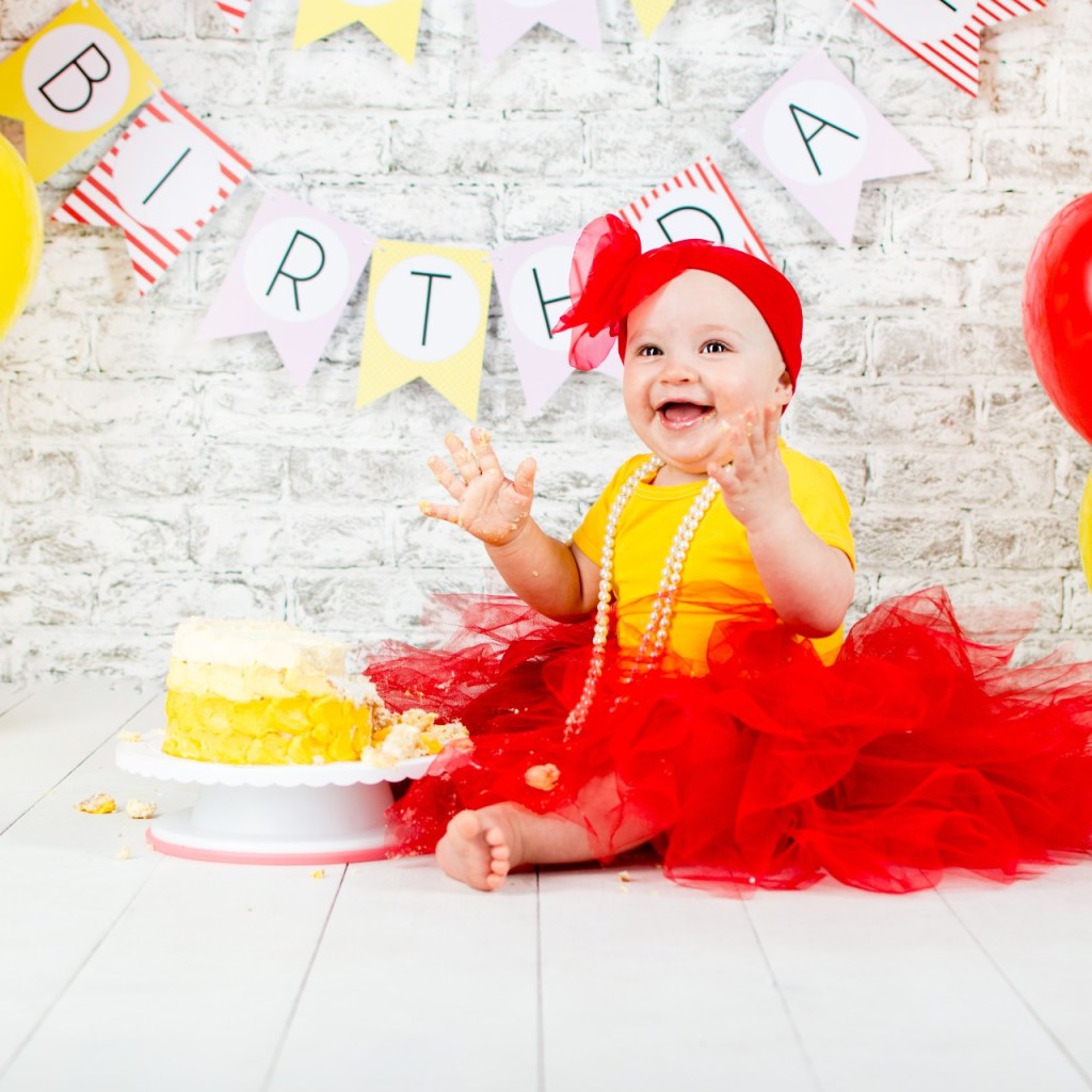 Little girl in red and yellow theme with smash cake