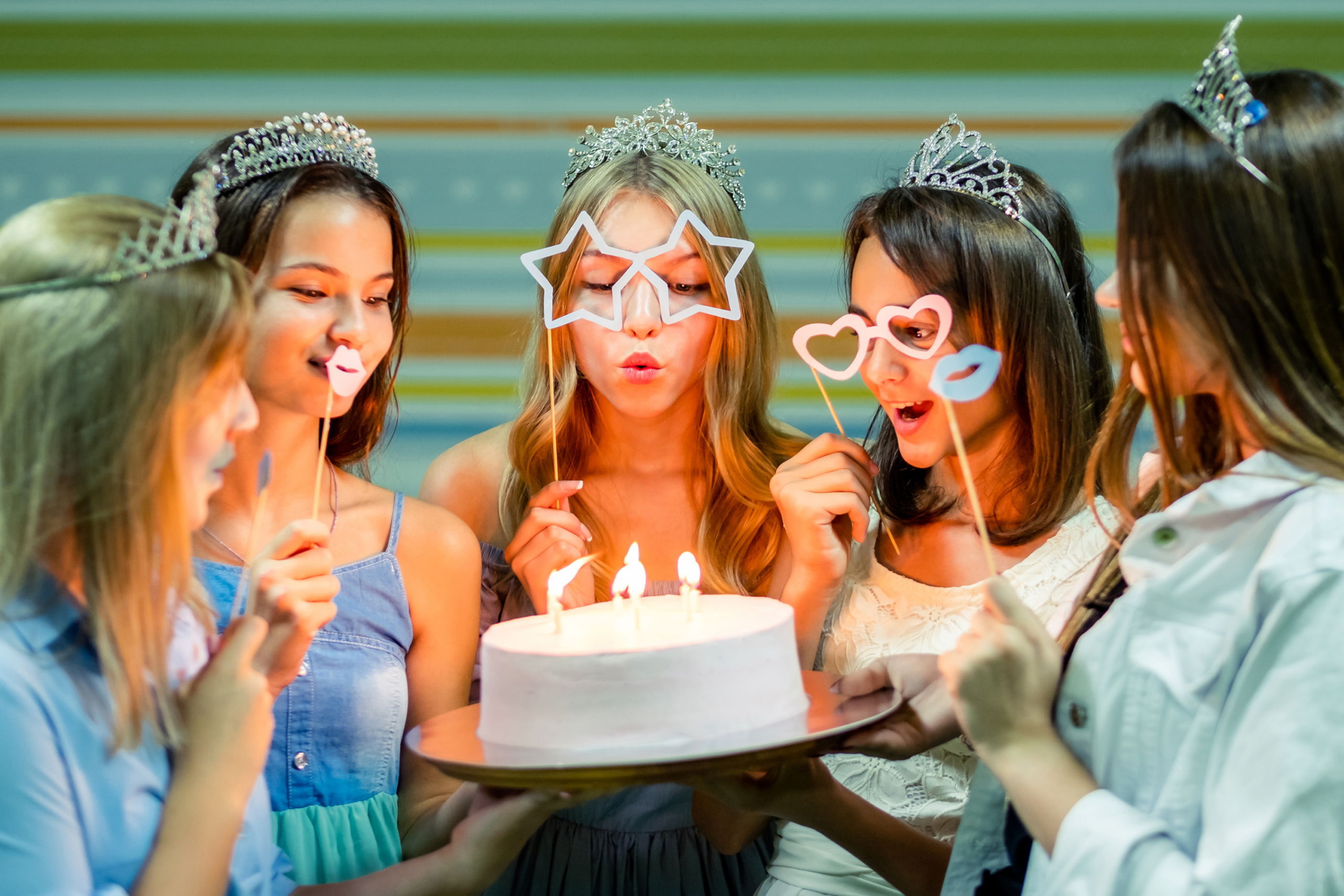 Five teenage girls near a birthday cake