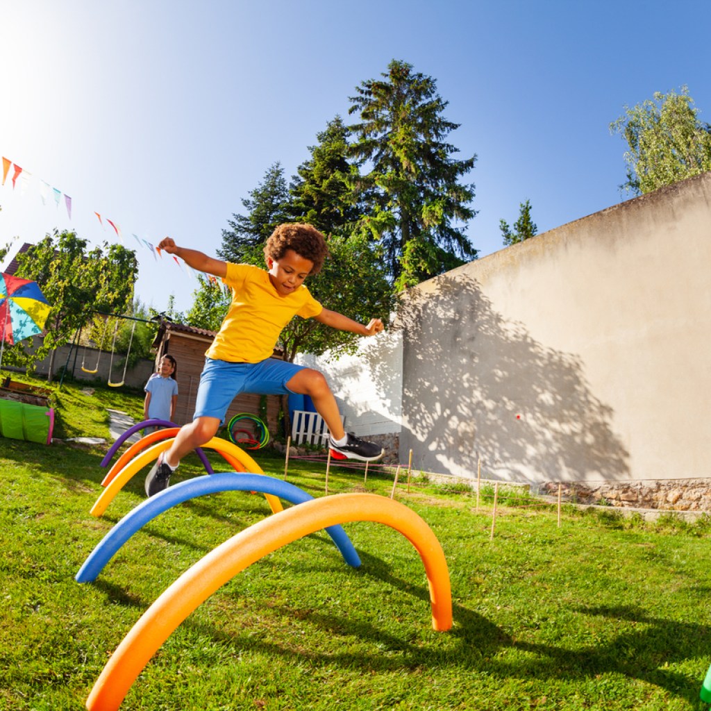 Child doing an obstacle course in the yard.