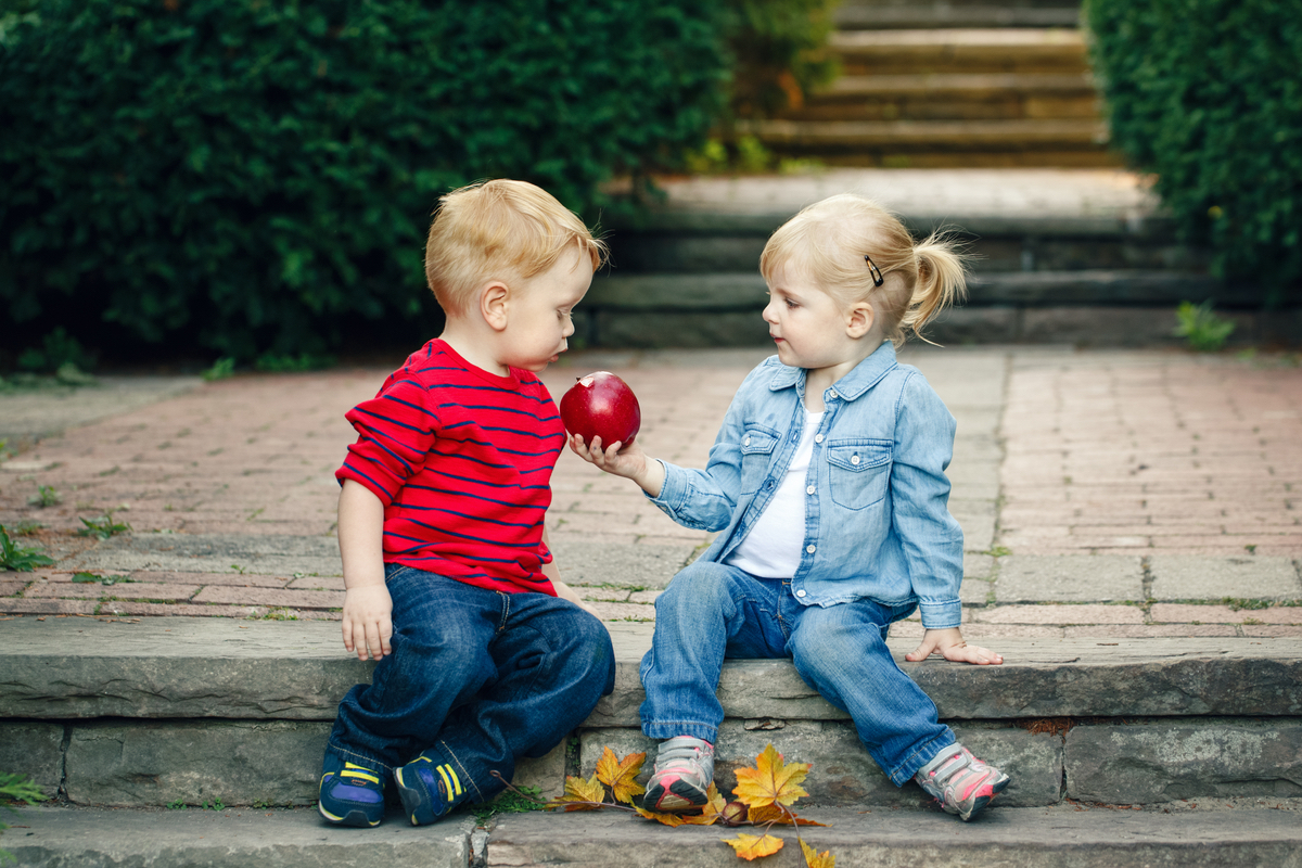 Toddlers share an apple