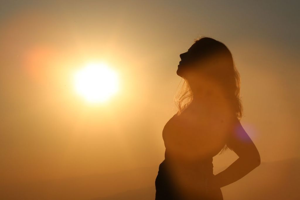 Pregnant woman facing the sun
