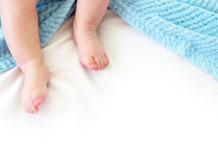 Baby feet sticking out from a blue blanket