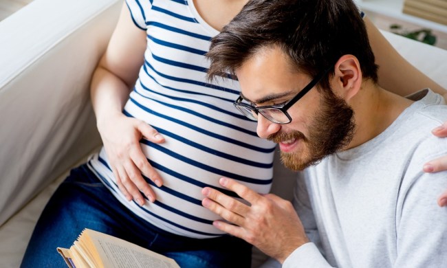 A dad reading to baby in mom's belly.