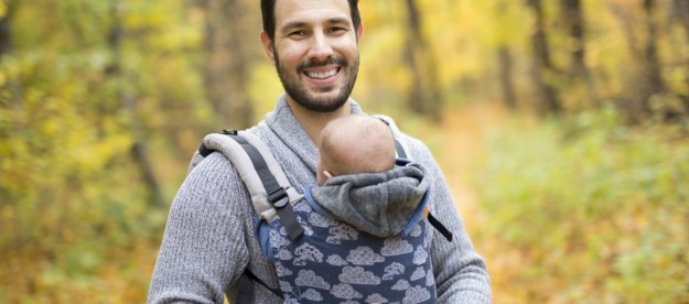 A dad wearing his baby in a carrier